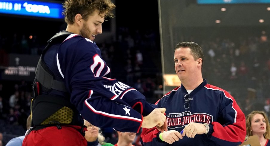 Hockey fan Doug Vance receives the jersey off the back of Columbus Blue Jackets center Alexander Wennberg (10) after a game against the Carolina Hurricanes at Nationwide Arena.