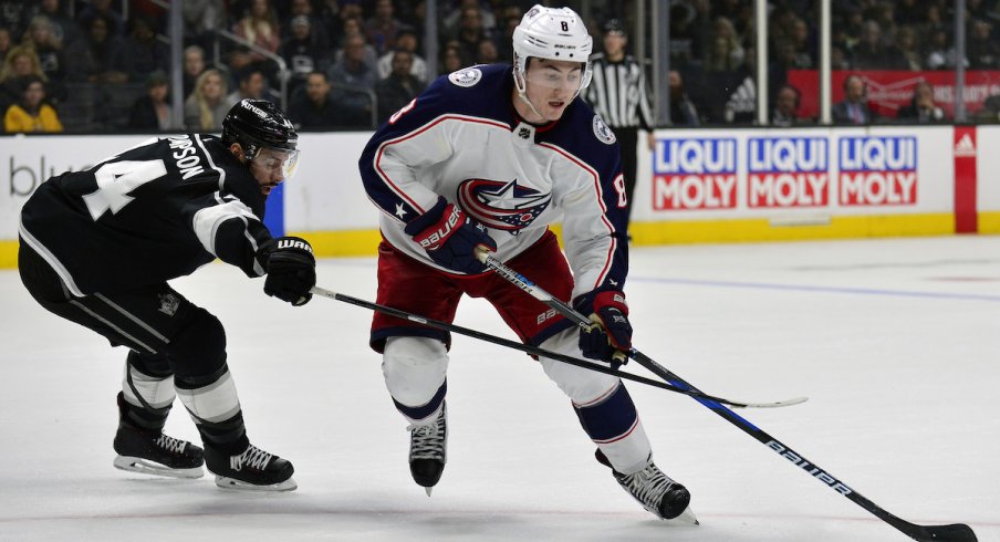 Columbus Blue Jackets defenseman Zach Werenski protects the puck against Nate Thompson of the Los Angeles Kings during a game at STAPLES Center.