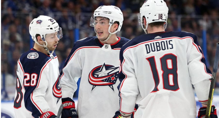 Columbus Blue Jackets forward Oliver Bjorkstrand, defenseman Zach Werenski and center Pierre-Luc Dubois discuss with one another at Amalie Arena during their matchup with the Tampa Bay Lightning in the 2019 Stanley Cup Playoffs.