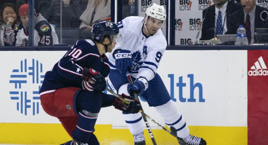 Columbus Blue Jackets center Alexander Wennberg defends against Toronto Maple Leafs center John Tavares during a game at Nationwide Arena.