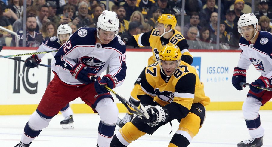 Columbus Blue Jackets forward Alexandre Texier battles with Pittsburgh Penguins forward Sydney Crosby during the Penguins' home opener for the 2019 NHL Regular Season. 