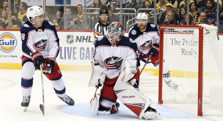 Oct 5, 2019; Pittsburgh, PA, USA; Columbus Blue Jackets goaltender Elvis Merzlikins (90) makes a save as defenseman Zach Werenski (8) defends against the Pittsburgh Penguins during the second period at PPG PAINTS Arena. The Penguins won 7-2.