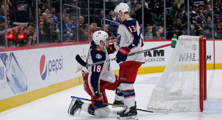 Columbus Blue Jackets center Pierre-Luc Dubois (18) celebrates with right wing Cam Atkinson (13) after scoring an empty net goal in the third period against the Colorado Avalanche at the Pepsi Center. 