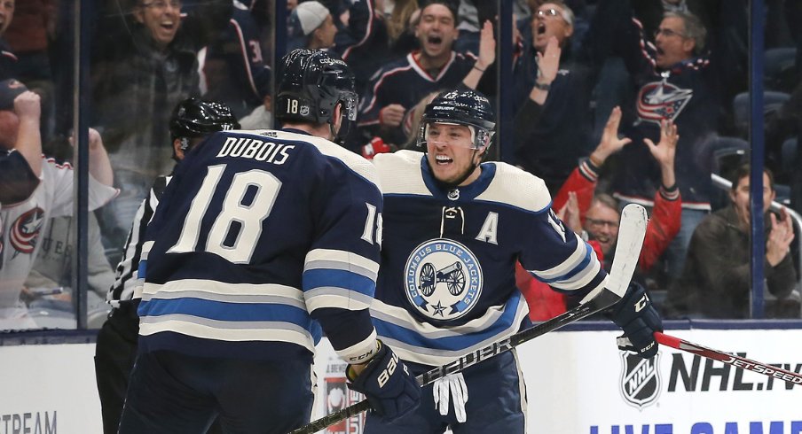 Columbus Blue Jackets forwards Pierre-Luc Dubois and Cam Atkinson celebrate after a game-winning goal in overtime to defeat the Carolina Hurricanes at Nationwide Arena during October of 2019.