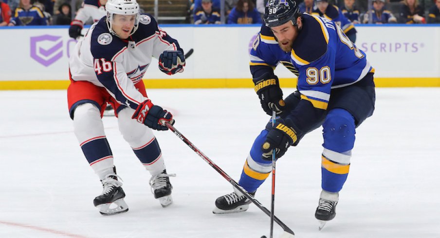 St. Louis Blues center Ryan O'Reilly (90) and Columbus Blue Jackets defenseman Dean Kukan (46) battle for the puck during the first period at Enterprise Center. 