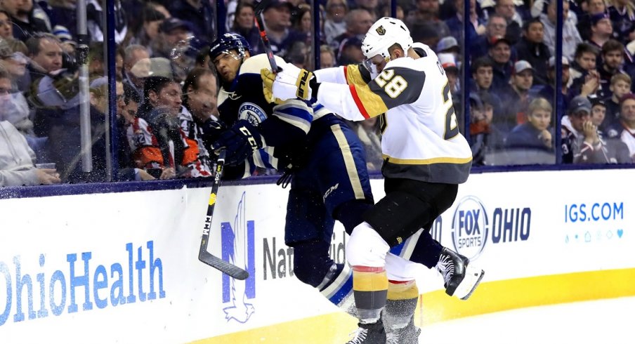 Columbus Blue Jackets defenseman Seth Jones (3) is checked along the boards by Vegas Golden Knights left wing William Carrier (28) in the third period at Nationwide Arena.