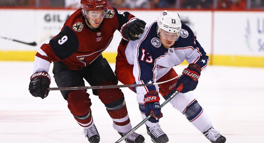 Jan 25, 2018; Glendale, AZ, USA; Arizona Coyotes center Clayton Keller (9) battles for the puck against Columbus Blue Jackets right wing Cam Atkinson (13) in the third period at Gila River Arena. Mandatory Credit: Mark J. Rebilas-USA TODAY Sports