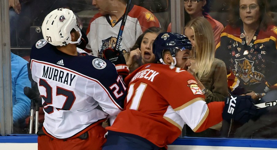 Oct 11, 2018; Sunrise, FL, USA; Columbus Blue Jackets defenseman Ryan Murray (27) is checked into the boards by Florida Panthers center Vincent Trocheck (21) during the third period at BB&T Center.