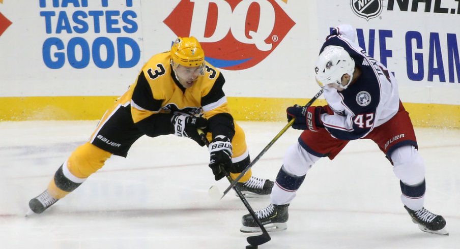 Pittsburgh Penguins defenseman Jack Johnson (3) and Columbus Blue Jackets center Alexandre Texier (42) battle for the puck during the second period at PPG PAINTS Arena. Mandatory Credit: Charles LeClaire-USA TODAY Sports