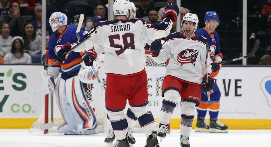 Dec 23, 2019; Uniondale, New York, USA; Columbus Blue Jackets left wing Nathan Gerbe (24) celebrates his goal against New York Islanders goalie Thomas Greiss (1) with Blue Jackets defenseman David Savard (58) during the second period at Nassau Veterans Memorial Coliseum.