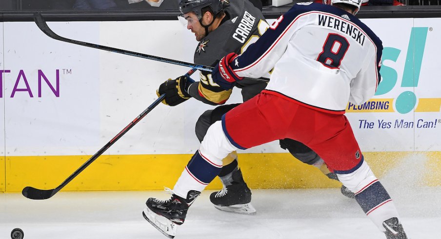 Columbus Blue Jackets defenseman Zach Werenski (8) checks Vegas Golden Knights left wing William Carrier (28) during the first period at T-Mobile Arena