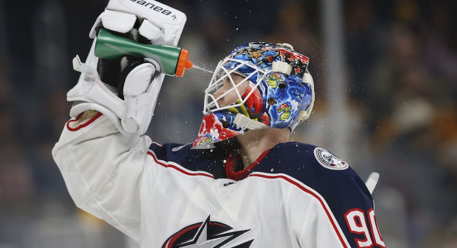 Columbus Blue Jackets goaltender Elvis Merzlikins (90) sprays water on his face during the third period against the Boston Bruins at TD Garden.