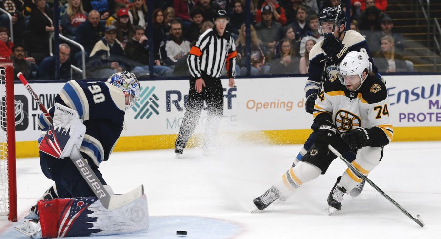 Columbus Blue Jackets goalie Elvis Merzlikins (90) makes a save from the shot of Boston Bruins left wing Jake DeBrusk (74) during the first period at Nationwide Arena.