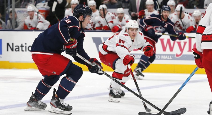 Columbus Blue Jackets defenseman Zach Werenski (8) carries the puck against Carolina Hurricanes right wing Martin Necas (88) during the first period at Nationwide Arena.