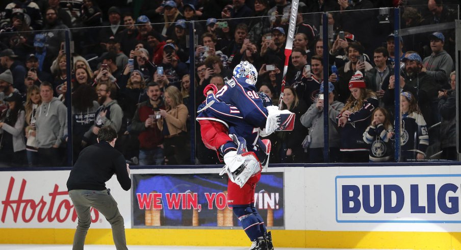 Columbus Blue Jackets goalie Elvis Merzlikins (90) and Columbus Blue Jackets left wing Nick Foligno (71) celebrate the win over the Carolina Hurricanes after the game at Nationwide Arena.