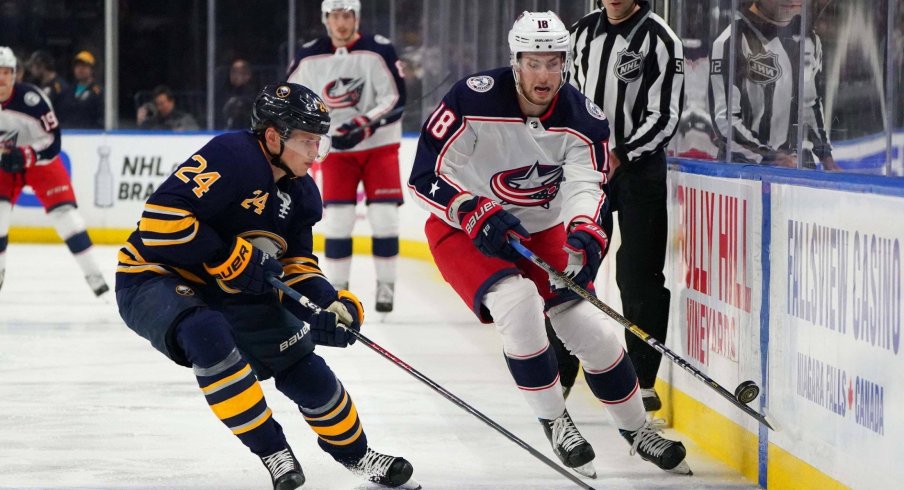 Mar 31, 2019; Buffalo, NY, USA; Buffalo Sabres defenseman Lawrence Pilut (24) and Columbus Blue Jackets center Pierre-Luc Dubois (18) go after a loose puck during the first period at KeyBank Center. Mandatory Credit: Kevin Hoffman-USA TODAY Sports