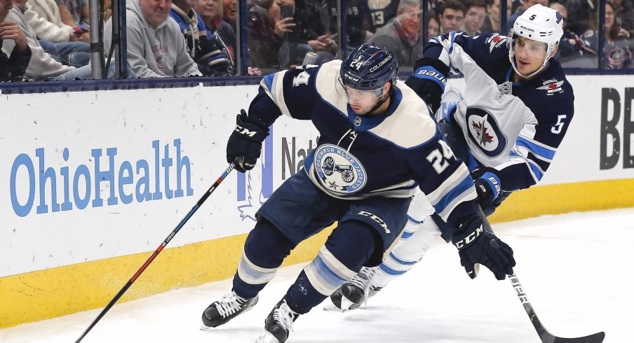 Jan 22, 2020; Columbus, Ohio, USA; Columbus Blue Jackets center Nathan Gerbe (24) carries the puck away from Winnipeg Jets defenseman Luca Sbisa (5) during the second period at Nationwide Arena.