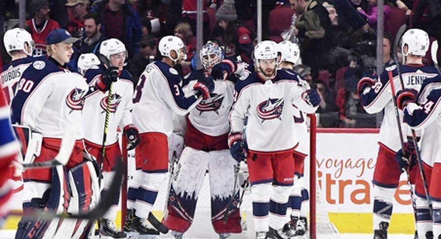 The Columbus Blue Jackets surround goaltender Elvis Merzlikins after a win over the Montreal Canadiens at the Bell Centre.