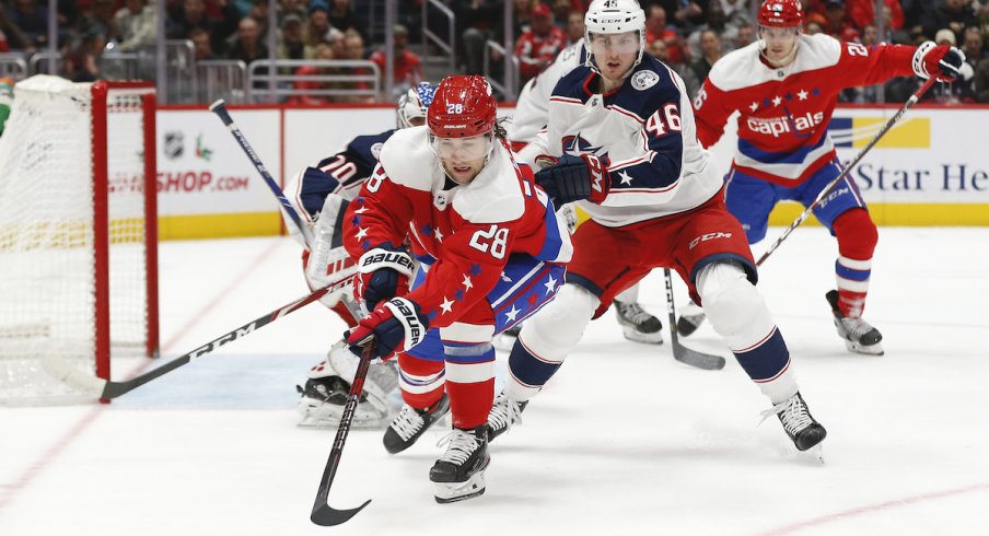 Columbus Blue Jackets defenseman Dean Kukan defends against Brendan Leipsic of the Washington Capitals.