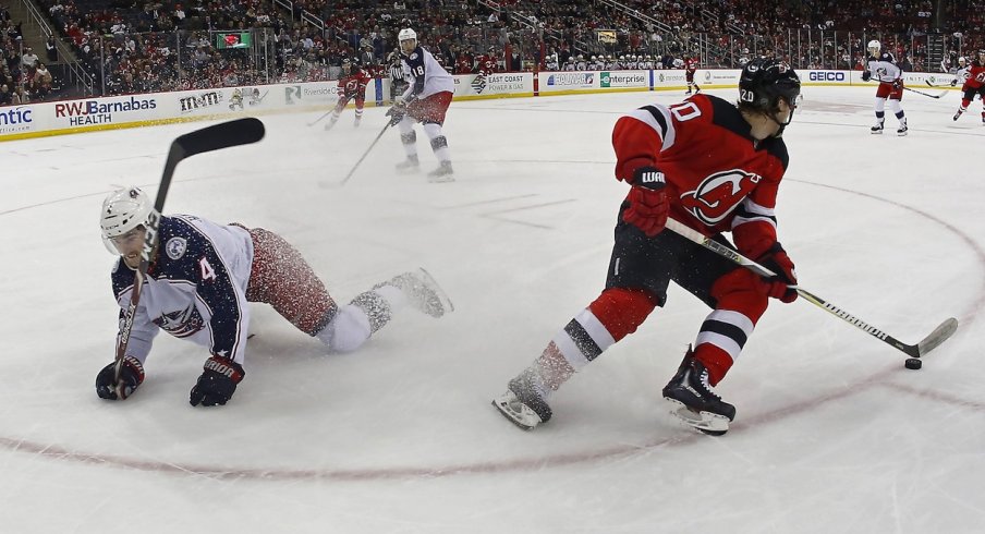 New Jersey Devils center Blake Coleman (20) plays the puck against Columbus Blue Jackets defenseman Scott Harrington (4) during the second period at Prudential Center. 