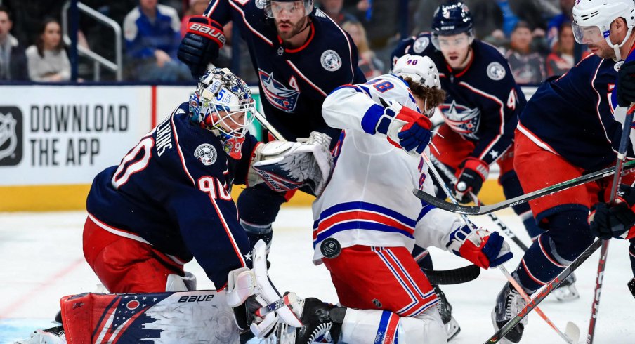 Feb 14, 2020; Columbus, Ohio, USA; Columbus Blue Jackets goaltender Elvis Merzlikins (90) makes a save in net against New York Rangers left wing Brendan Lemieux (48) in the third period at Nationwide Arena. Mandatory Credit: Aaron Doster-USA TODAY Sports