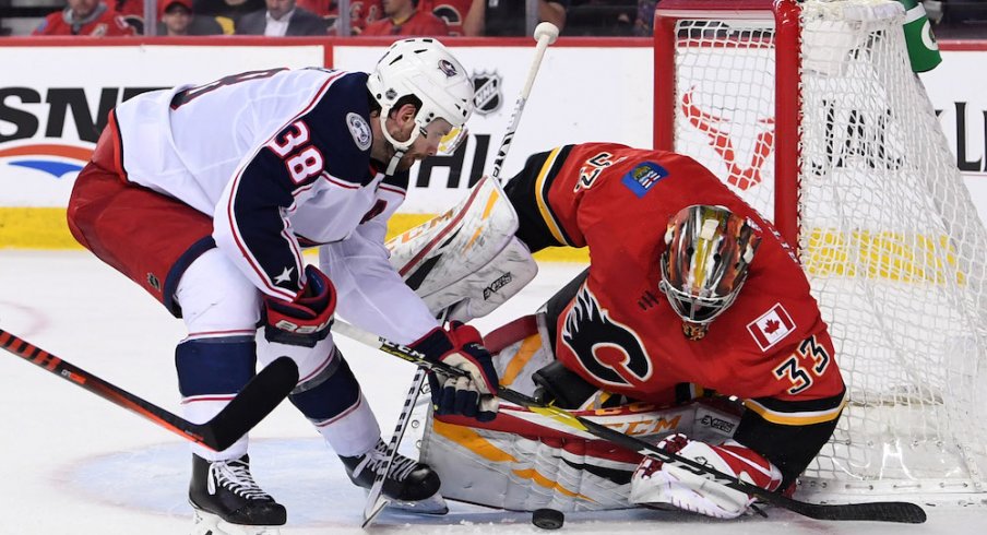 Calgary Flames goalie David Rittich (33) makes a save against Columbus Blue Jackets center Boone Jenner (38) during the second period at Scotiabank Saddledome. 