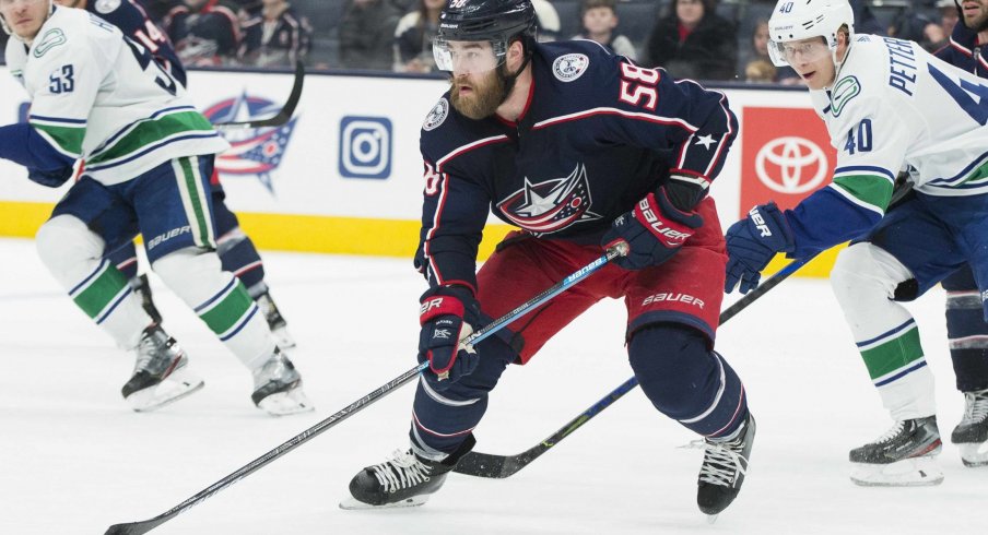 Columbus Blue Jackets defenseman David Savard (58) advances the puck defended by Vancouver Canucks center Elias Pettersson (40) in the third period at Nationwide Arena.