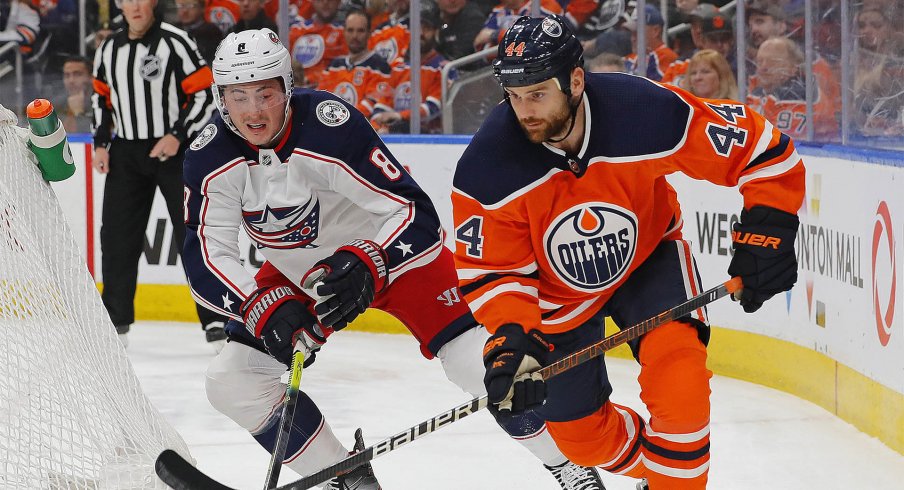 Mar 7, 2020; Edmonton, Alberta, CAN; Columbus Blue Jackets defensemen Zack Werenski (8) and Edmonton Oilers forward Zack Kassian (44) battle for a loose puck during the first period at Rogers Place.