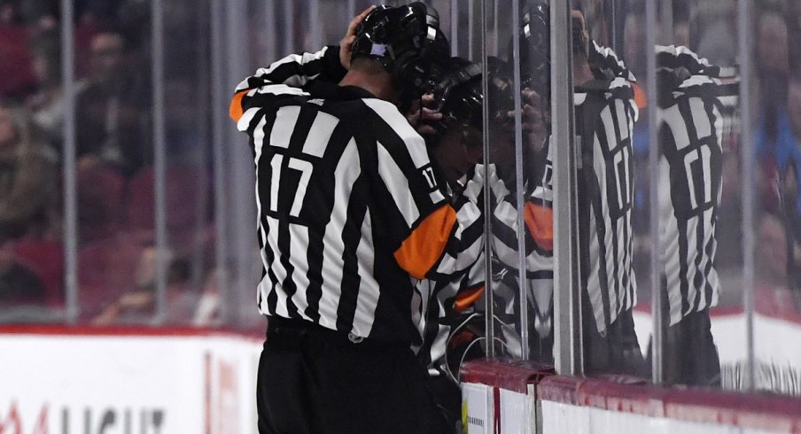 A referee reviews a play in the NHL