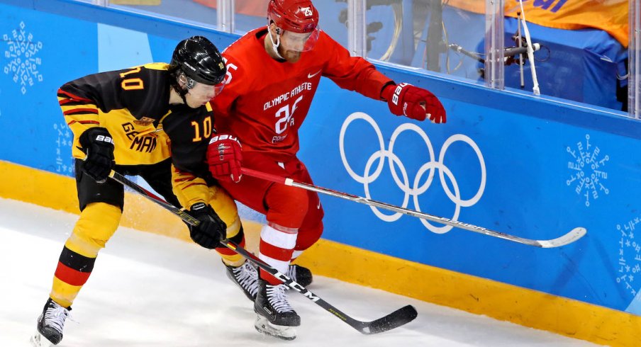 Germany defenseman Christian Ehrhoff (10) and Olympic Athlete from Russia forward Mikhail Grigorenko (25) go for the puck in the men's ice hockey gold medal match during the Pyeongchang 2018 Olympic Winter Games at Gangneung Hockey Centre.