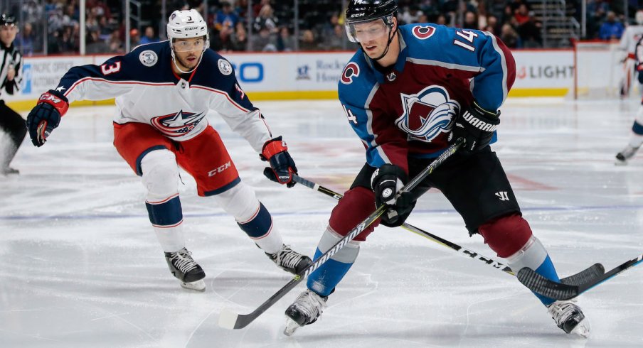 Colorado Avalanche forward Blake Comeau skates with the puck while Columbus Blue Jackets defenseman Seth Jones defends during a game at Pepsi Center in Denver, Colorado.