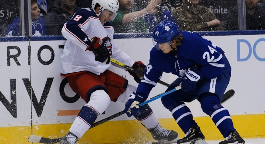 Zach Werenski and Kasperi Kapanen battle for the puck