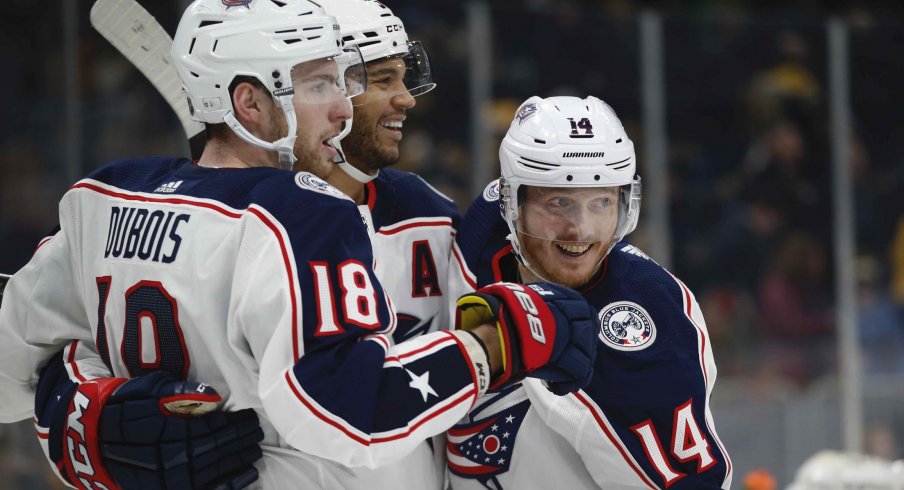 Columbus Blue Jackets center Pierre-Luc Dubois (18) celebrates with defenseman Seth Jones (3) and center Gustav Nyquist (14) after scoring the game winning goal during the overtime period against the Boston Bruins at TD Garden.