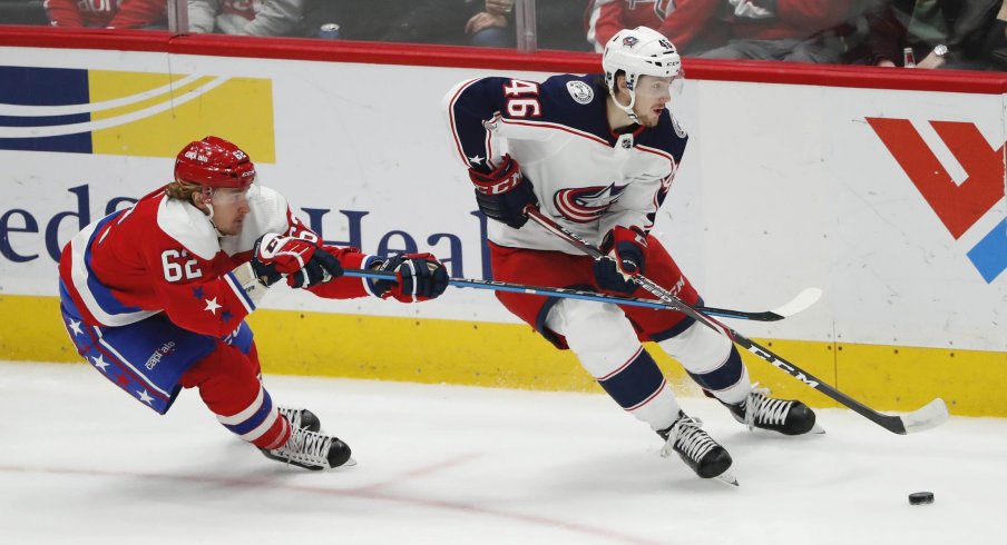 Columbus Blue Jackets defenseman Dean Kukan (46) skates with the puck as Washington Capitals left wing Carl Hagelin (62) defends in the third period at Capital One Arena.