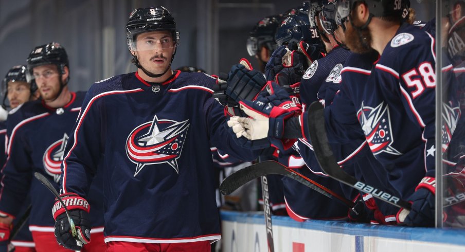 Zach Werenski #8 of the Columbus Blue Jackets skates by the bench to celebrate with teammates after Werenski scored a goal during the first period of an exhibition game against the Boston Bruins prior to the 2020 NHL Stanley Cup Playoffs at Scotiabank Arena on July 30, 2020 in Toronto, Ontario.