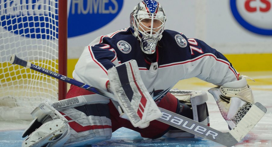 Columbus Blue Jackets goaltender Joonas Korpisalo stretches between stoppages in play.