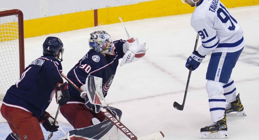 ug 7, 2020; Toronto, Ontario, CAN; Columbus Blue Jackets goaltender Elvis Merzlikins (90) makes a glove save as Toronto Maple Leafs forward John Tavares (91) looks on during the second period of game four of the Eastern Conference qualifications at Scotiabank Arena.