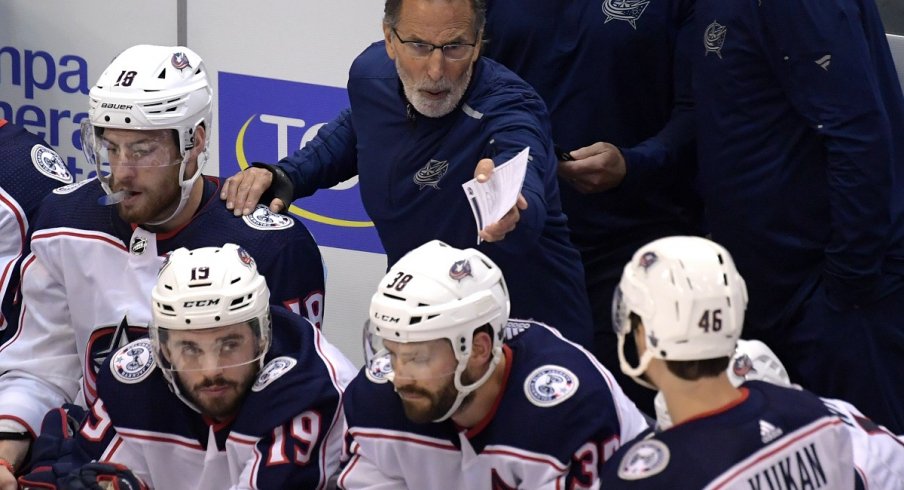 John Tortorella communicates with his players from behind the bench