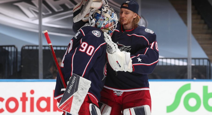 Goaltender Joonas Korpisalo #70 of the Columbus Blue Jackets congratulates fellow netminder Elvis Merzlikins #90 after an exhibition game against the Boston Bruins prior to the 2020 NHL Stanley Cup Playoffs at Scotiabank Arena on July 30, 2020 in Toronto, Ontario. The Blue Jackets defeated the Bruins 4-1.
