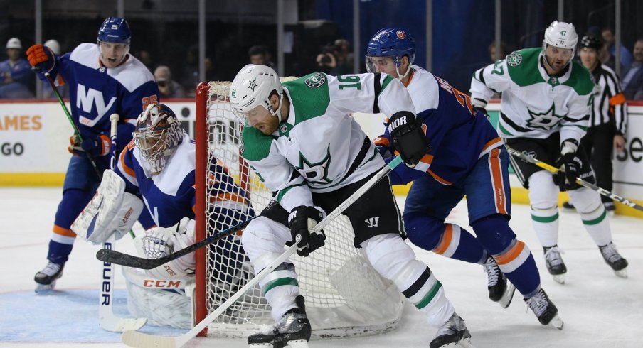 Joe Pavelski plays the puck against New York Islanders goalie Semyon Varlamov