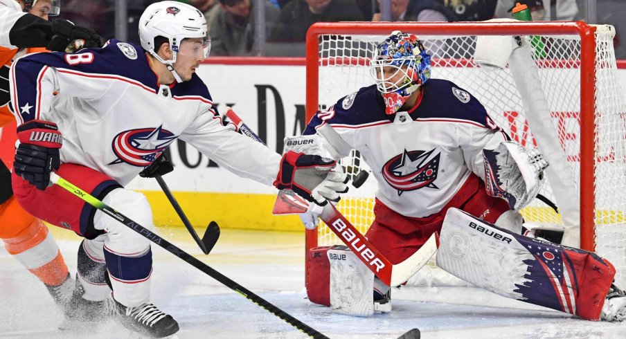 Feb 18, 2020; Philadelphia, Pennsylvania, USA; Columbus Blue Jackets defenseman Zach Werenski (8) reaches for the puck in front of goaltender Elvis Merzlikins (90) against the Philadelphia Flyers during the second period during the first period at Wells Fargo Center.