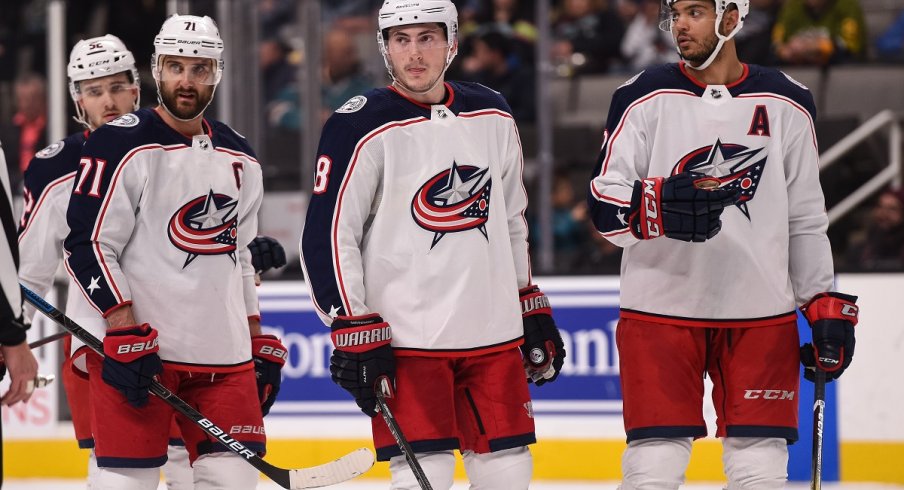 Nick Foligno, Zach Werenski, Seth Jones, and Emil Bemstrom before a faceoff 