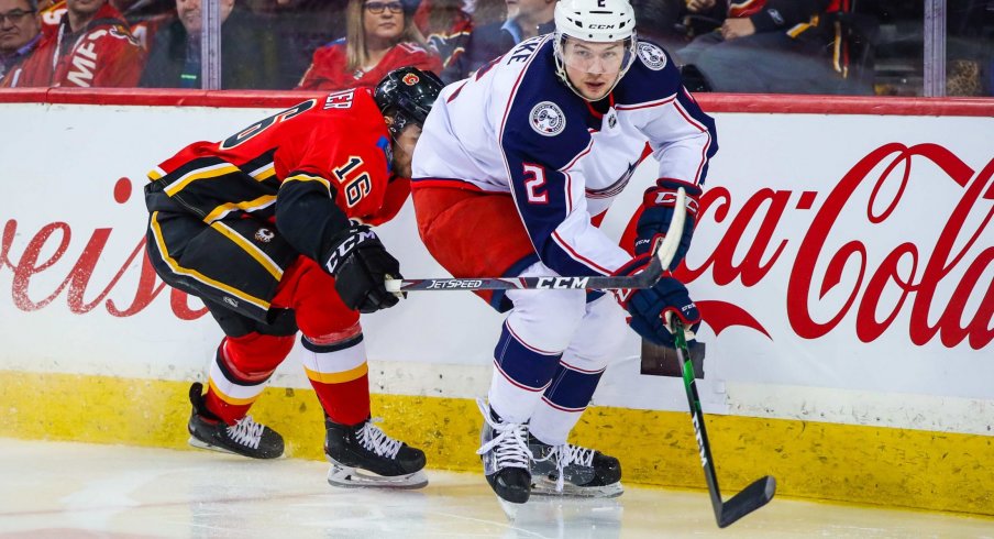 Mar 4, 2020; Calgary, Alberta, CAN; Columbus Blue Jackets defenseman Andrew Peeke (2) and Calgary Flames center Tobias Rieder (16) battle for the puck during the third period at Scotiabank Saddledome.