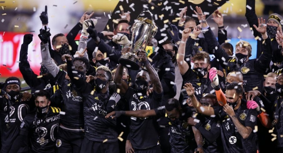  Columbus Crew defender Jonathan Mensah (4) hoists the MLS Cup trophy with his teammates after their 3-0 win over the Seattle Sounders in the MLS Cup at MAPFRE Stadium.