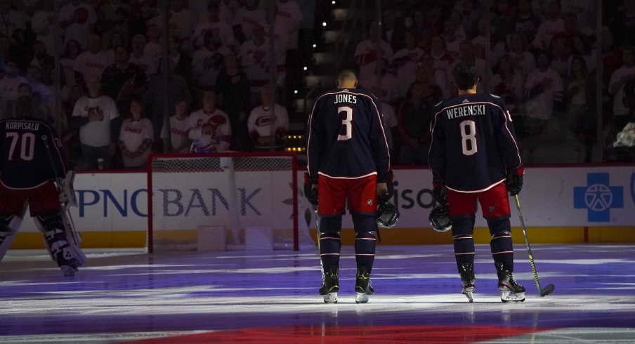 Zach Werenski and Seth Jones during the National Anthem before a game against the Carolina Hurricanes at PNC Arena