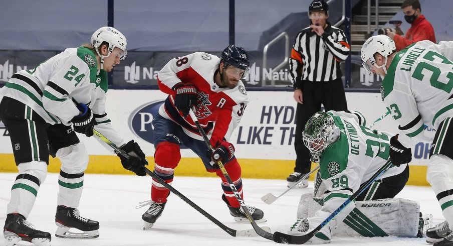 Dallas Stars goalie Jake Oettinger makes a save as Columbus Blue Jackets center Boone Jenner looks for a rebound Tuesday at Nationwide Arena. 