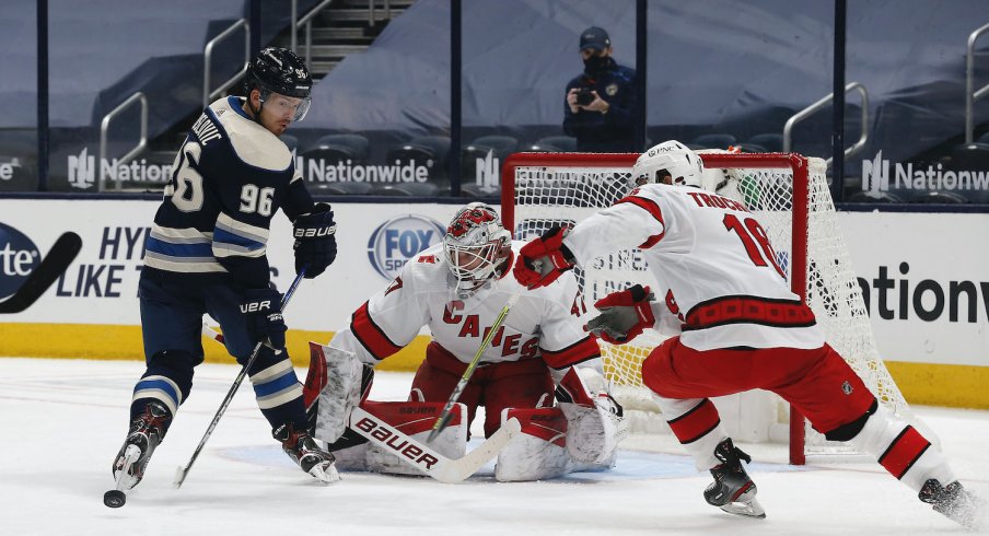 Columbus Blue Jackets center Jack Roslovic (96) reaches back for the loose puck from a Carolina Hurricanes goalie James Reimer (47) save during the third period at Nationwide Arena. 