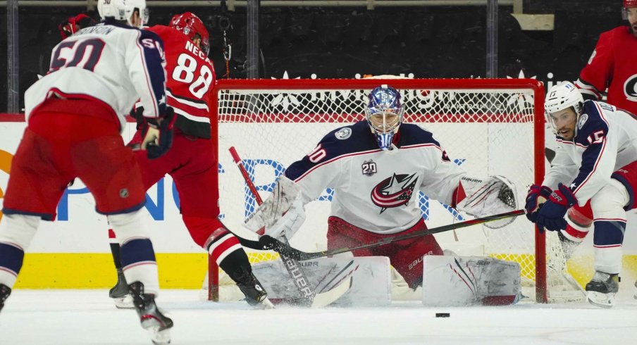 Feb 15, 2021; Raleigh, North Carolina, USA; Carolina Hurricanes center Martin Necas (88) and Columbus Blue Jackets goaltender Elvis Merzlikins (90) watch the puck during the third period at PNC Arena.