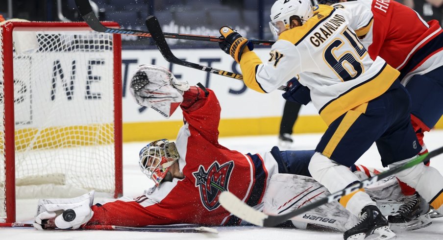  Elvis Merzlikins reaches to make a save against Nashville Predators center Mikael Granlund