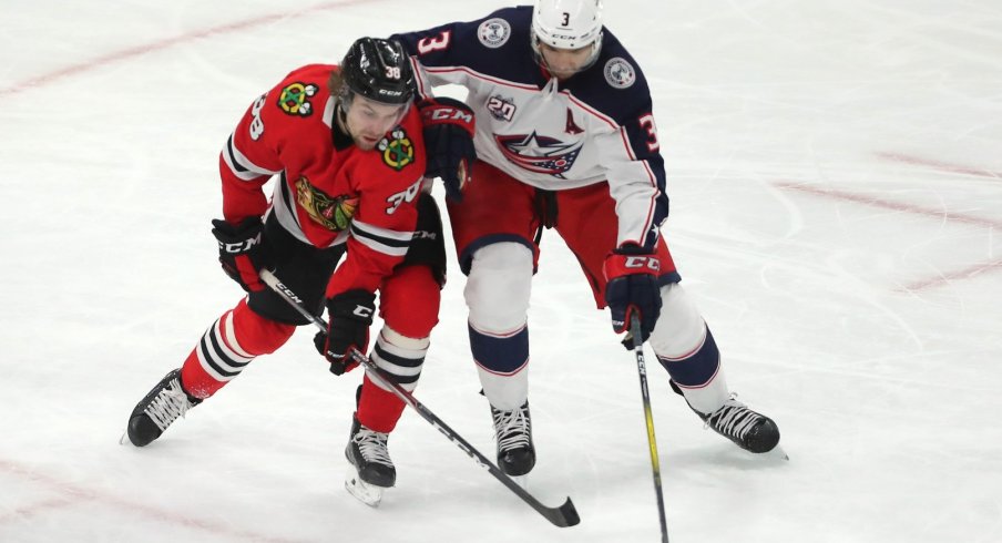 Chicago Blackhawks left wing Brandon Hagel (38) and Columbus Blue Jackets defenseman Seth Jones (3) fight for the puck during the second period at the United Center.